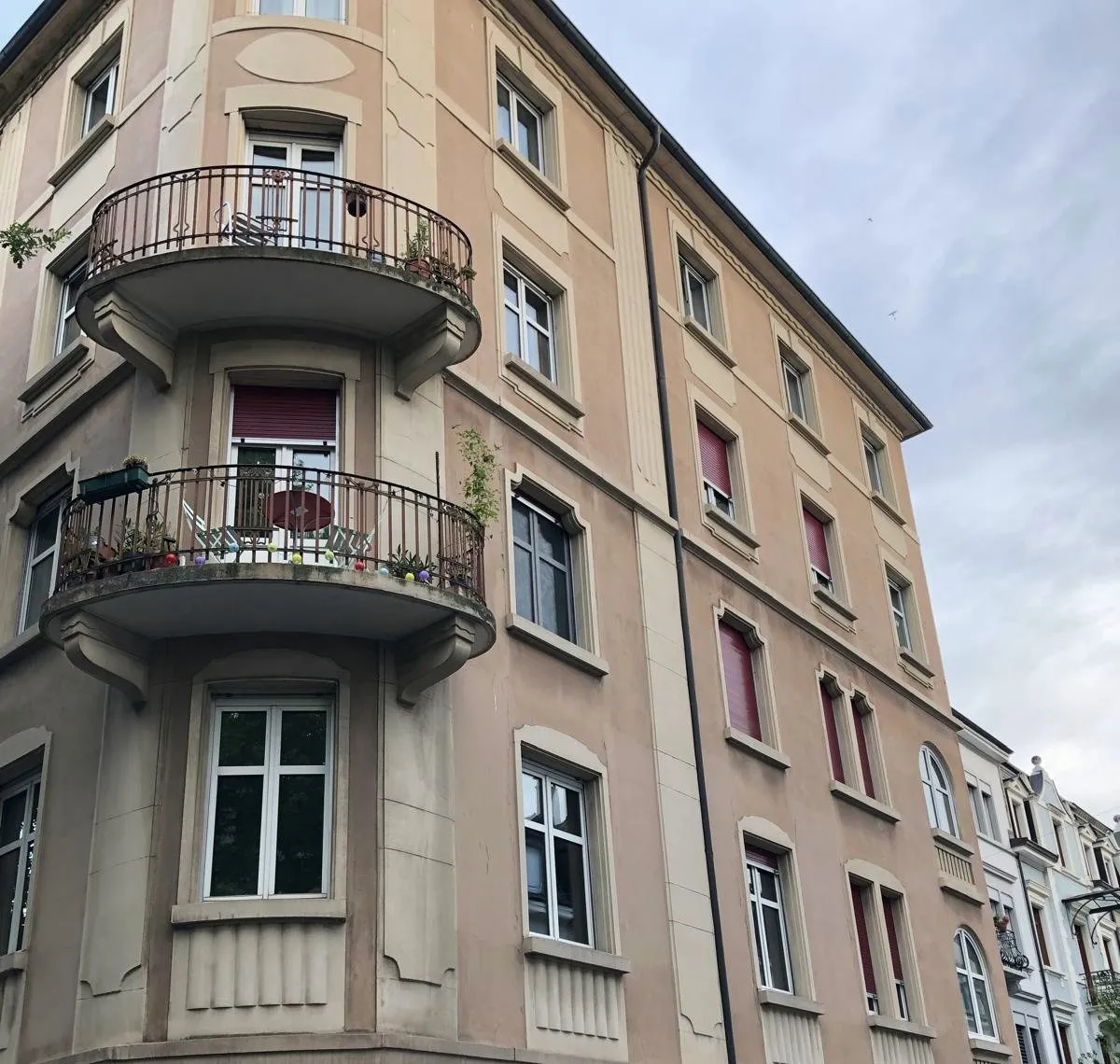 Eckhaus mit beiger Fassade vor dem Neuanstrich